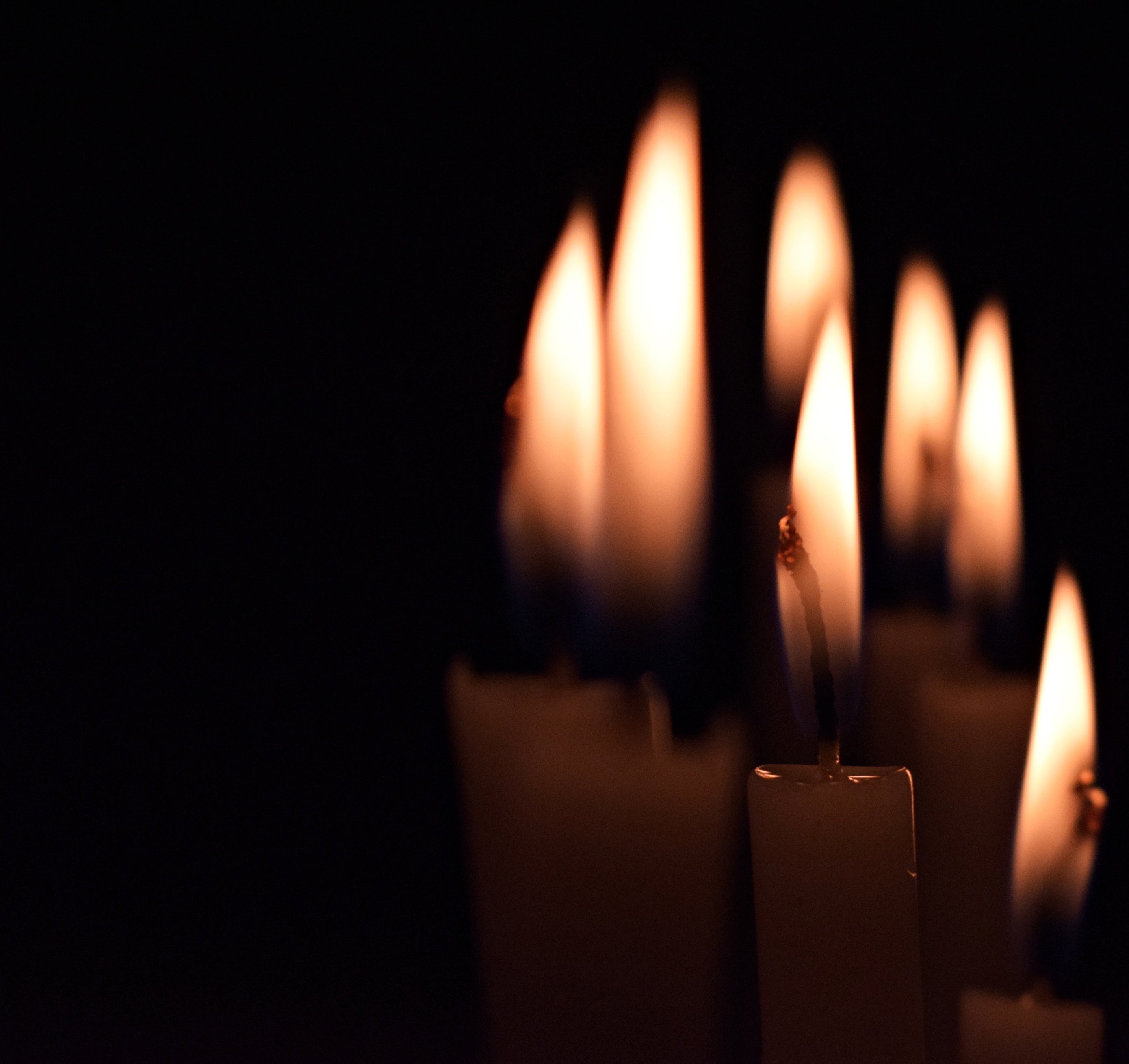 Close-up of lit candles against a dark background